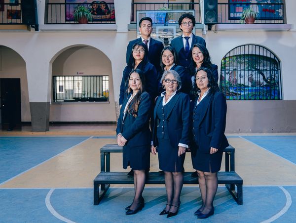 A group of professionals posing formally indoors in business attire.