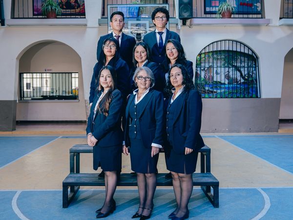 A group of professionals posing formally indoors in business attire.