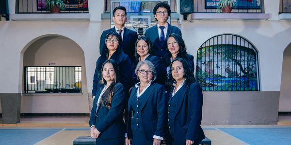 A group of professionals posing formally indoors in business attire.