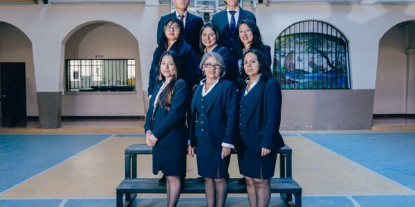 A group of professionals posing formally indoors in business attire.