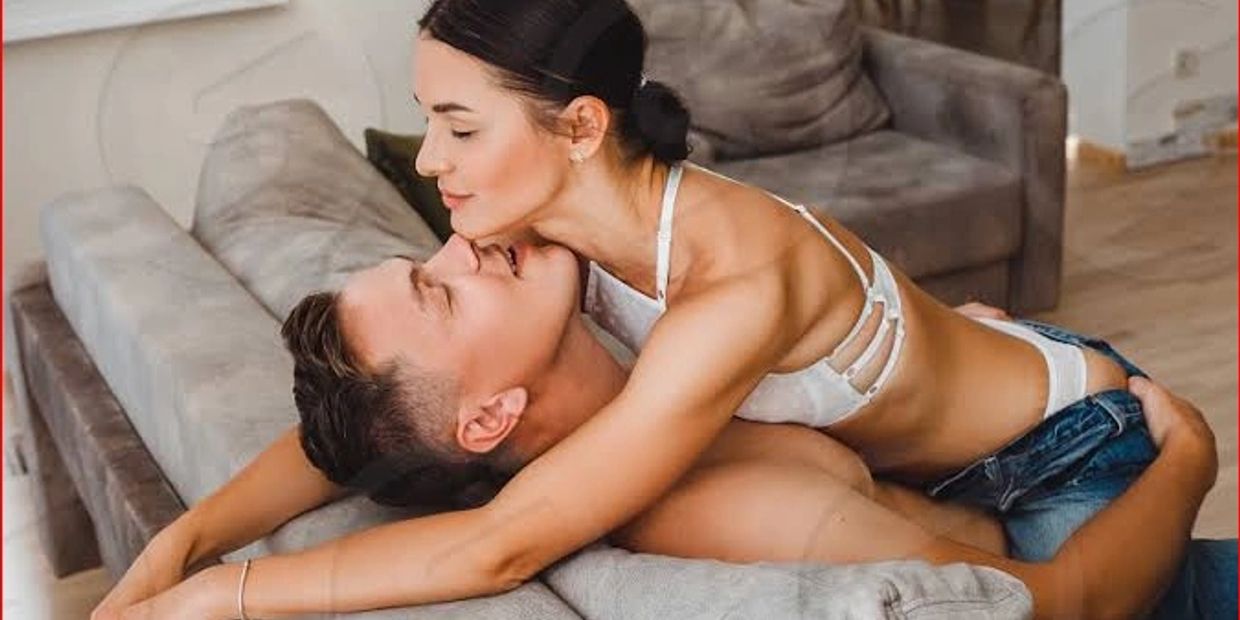 A couple sharing an intimate moment on a couch indoors.