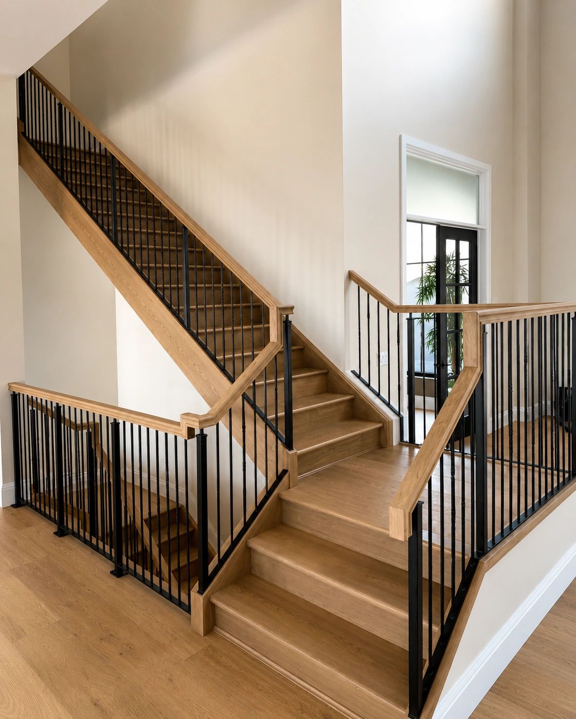 Modern wooden staircase with black metal railings in a bright home.