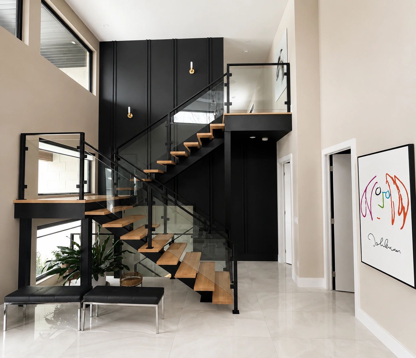 Modern staircase with glass railings and black accents in a bright home entrance.