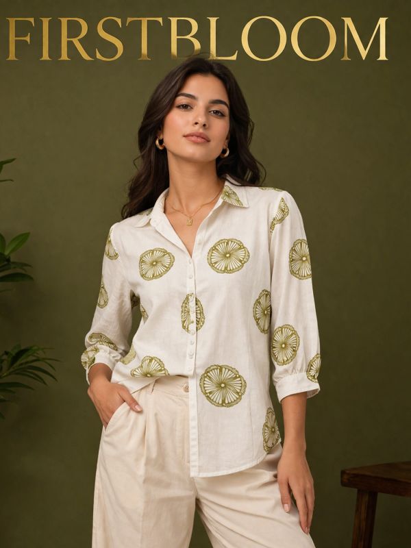 Woman wearing a printed white shirt and beige pants.