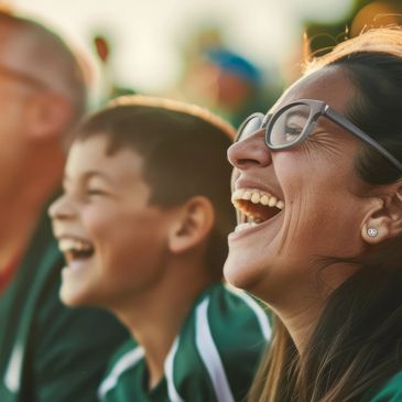 Woman and boy laughing joyfully outdoors.