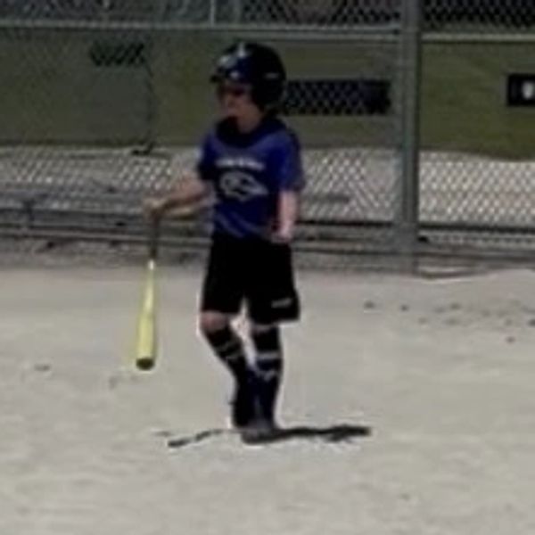 Young baseball player preparing to bat on the field.