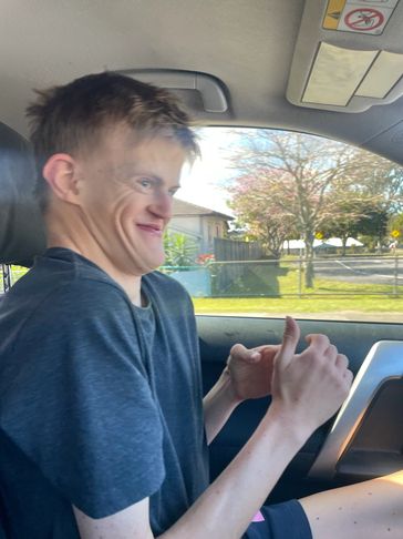 Young man making a humorous facial expression while sitting in a car.