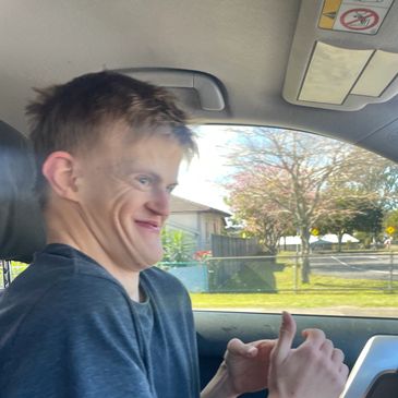 Young man making a humorous facial expression while sitting in a car.