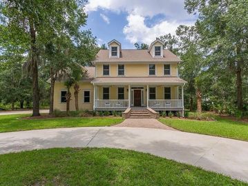 Large two-story house with yellow siding and a circular driveway.