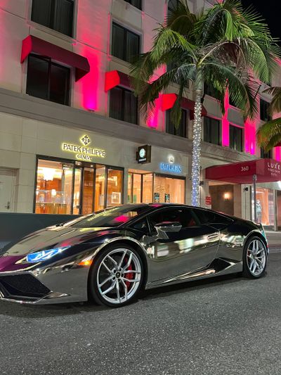 A Lamborghini Huracan in front of Patek Philippe and Rolex stores