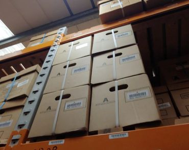 Stacked cardboard boxes on warehouse shelves.