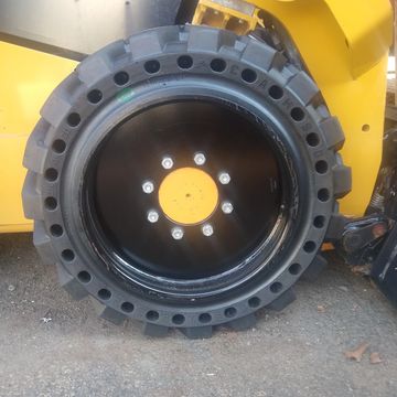 Skid steer solid tires, solid tire/wheel assembly, skid steer solid tire and wheel assemblies, skid 