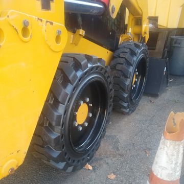 Skid steer solid tires, solid tire and wheel assembly for skid steers, solid tire and wheel, skid st