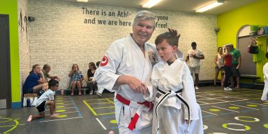 Martial arts instructor with student in dojo.