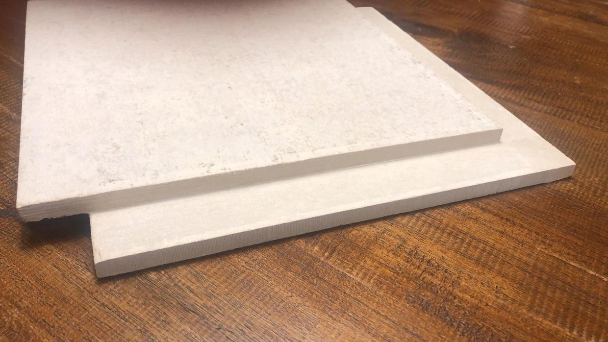 Two white rectangular foam sheets on a wooden surface.