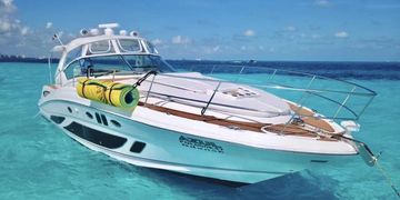 A white luxury yacht floating on clear turquoise water under a blue sky.