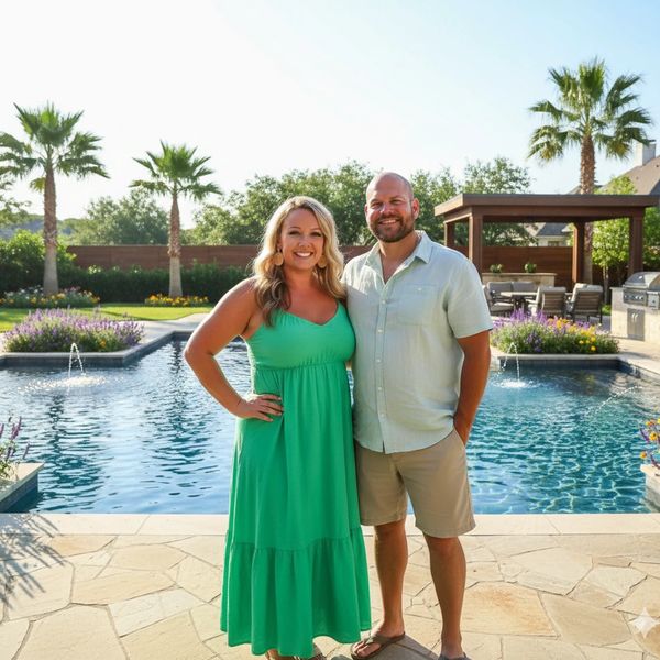 Couple smiling by a pool with palm trees in the background.