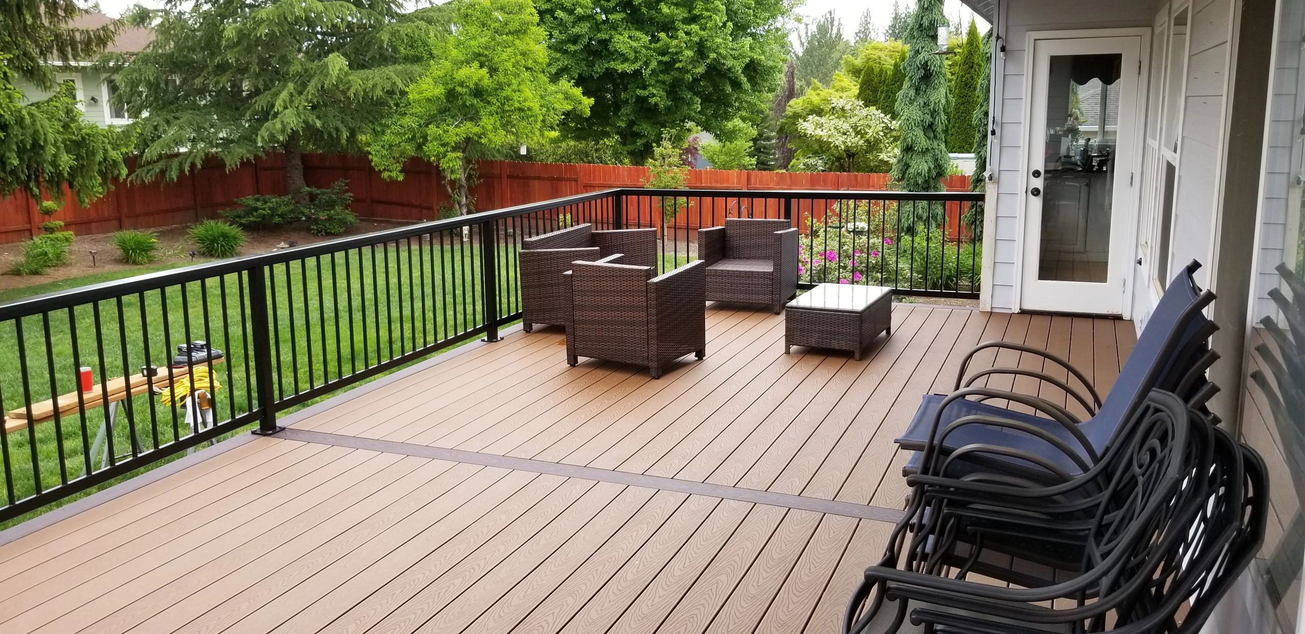 A view of a deck with railings and wooden chairs