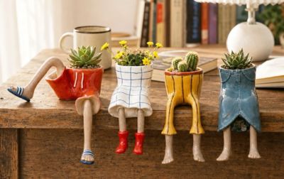 Creative planters shaped like trousers with legs, holding succulents and flowers.
