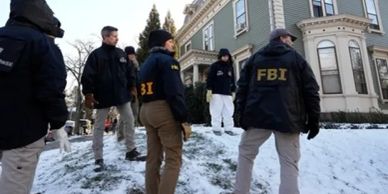 FBI agents outside a snowy residential house.