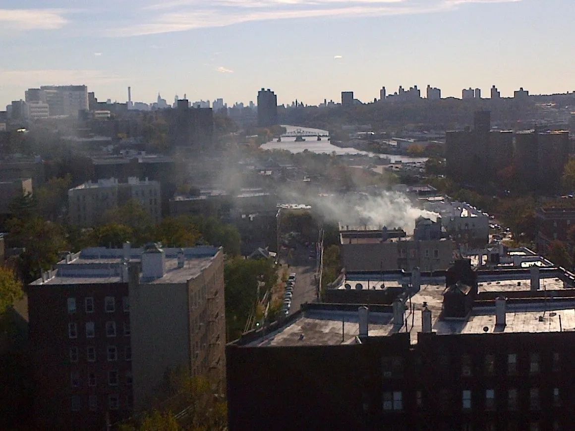 City skyline with smoke rising from buildings.