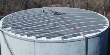 Large cylindrical tank with solar panels on roof.