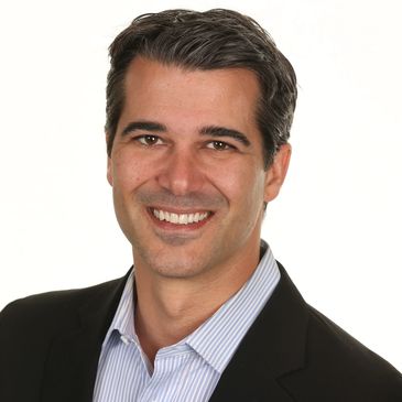 Smiling man in business attire against white background.