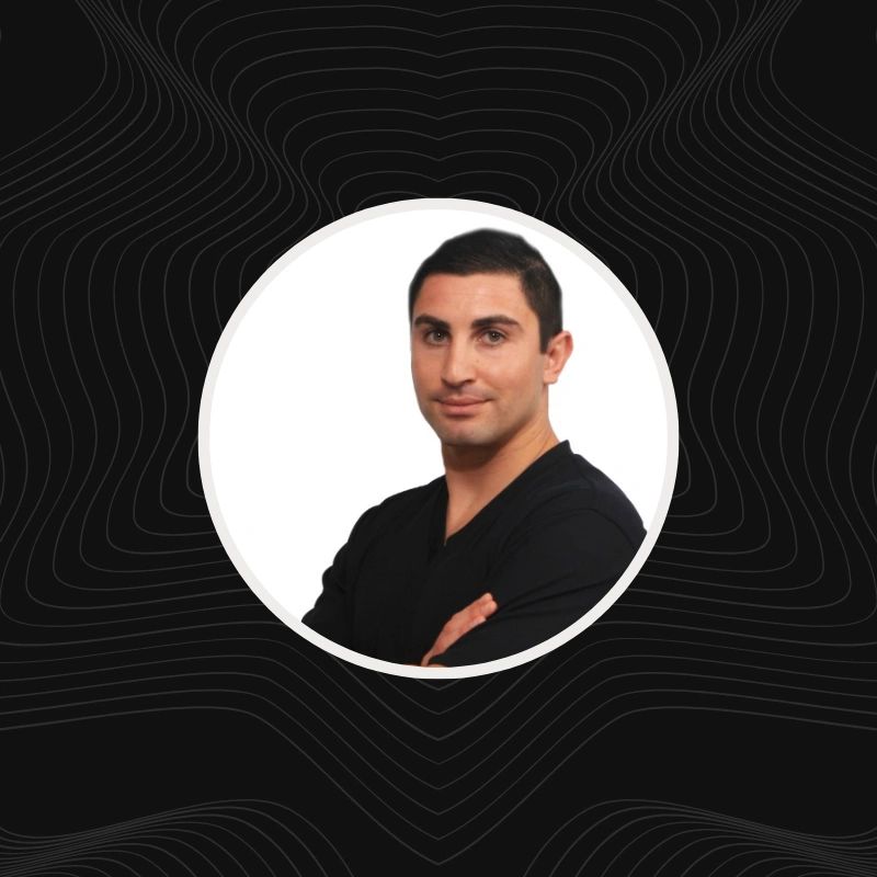 Portrait of a confident man with arms crossed against a white background.