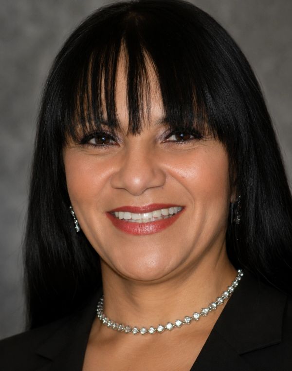 Smiling woman with long black hair and bangs.
