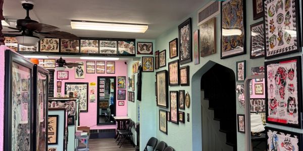 Tattoo shop interior with walls covered in tattoo designs and flash art.