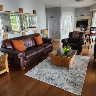Cozy living room with brown leather furniture and a woven coffee table.