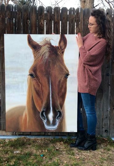 Artist Julia Strand posing with original equine artwork. Horse portrait fine art painting on canvas. 