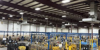 A large industrial warehouse with machinery and equipment under a high ceiling.