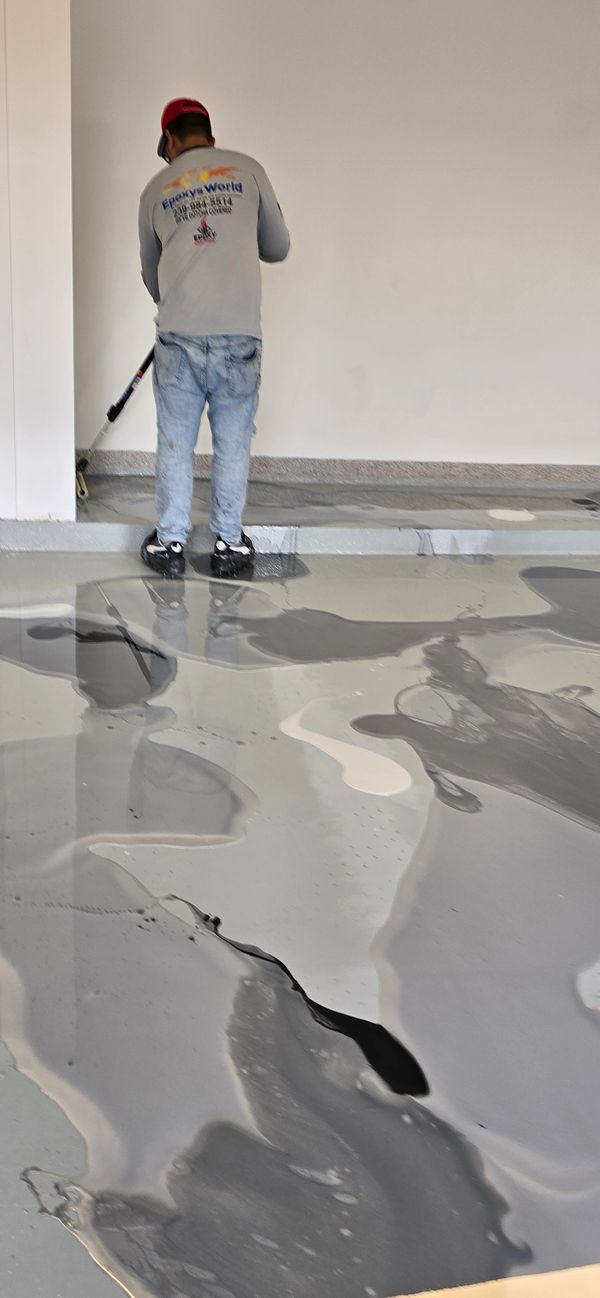Epoxy flooring crew applying metallic coating.