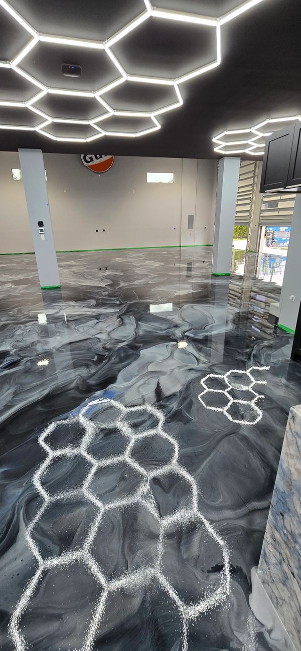Metallic epoxy floor with silver and charcoal swirl design.