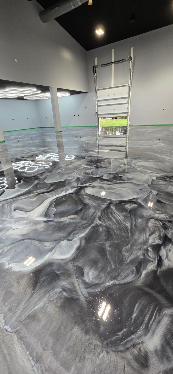 Metallic marbled epoxy floor with swirled dark, med, light gray and white patterns.