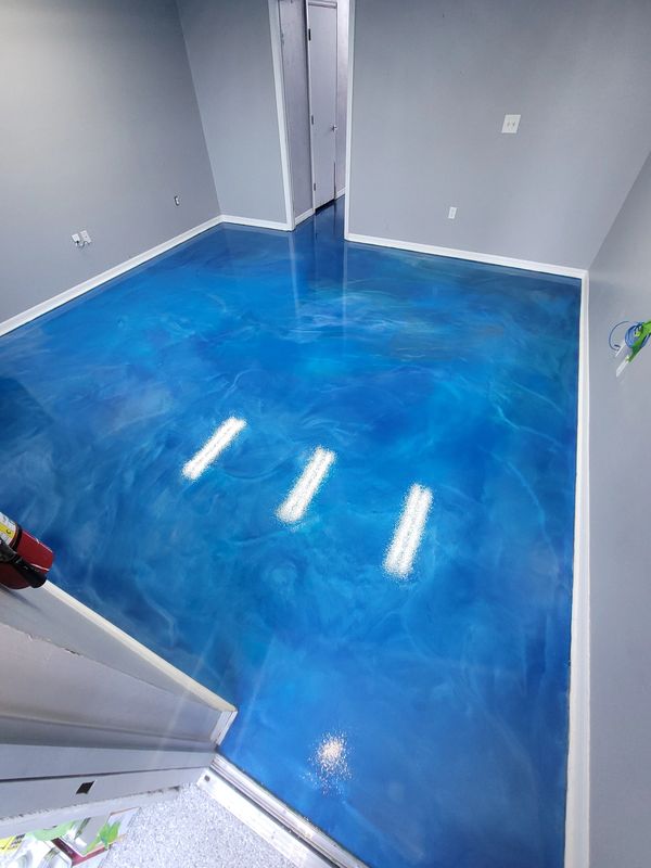 Blue metallic epoxy resin floor with gray walls, finished room.
