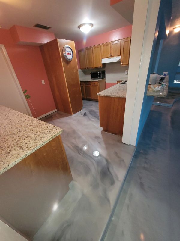 Old style kitchen with wood cabinets and marbled metallic epoxy floor.