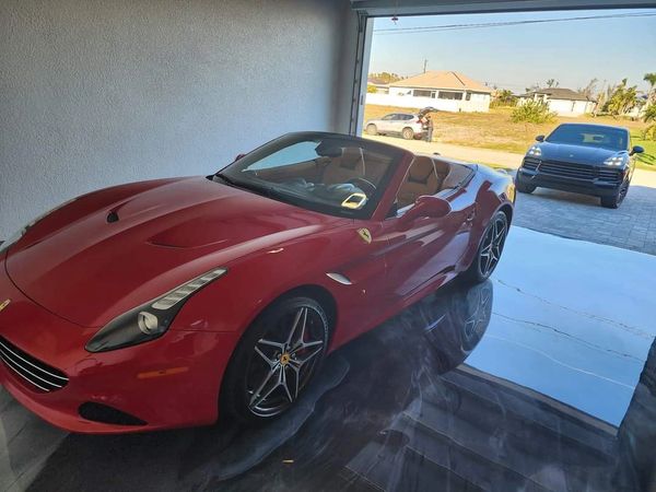 Red Ferrari parked on marble-effect metallic epoxy garage floor in Cape Coral.