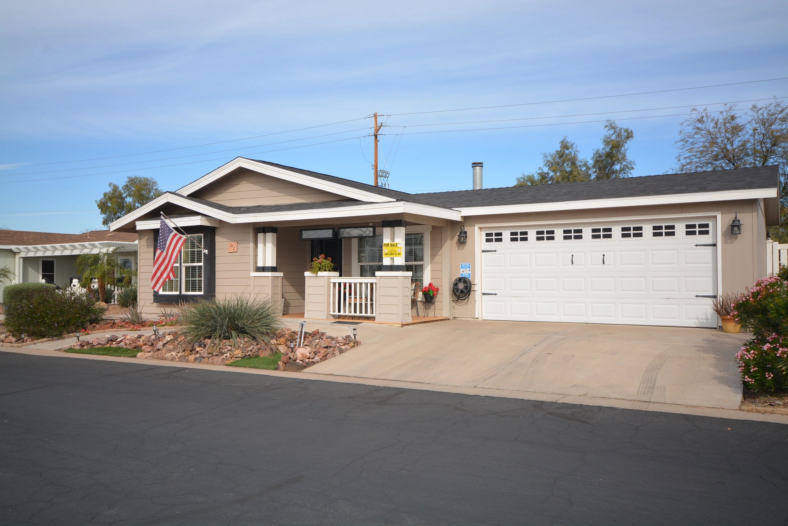Single-story house with a garage and an American flag outside.