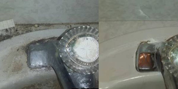 Old and worn bathtub faucet with crystal handles.