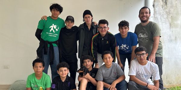 A group of young boys and a man posing indoors for a group photo.