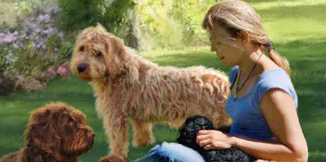 Woman sitting outdoors with three dogs.