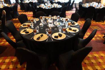 Elegant table setup for a formal event with black-themed decor.