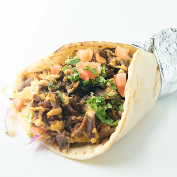 Lamb and beef gyro with tomatoes, onions, lettuce, and sauce.
