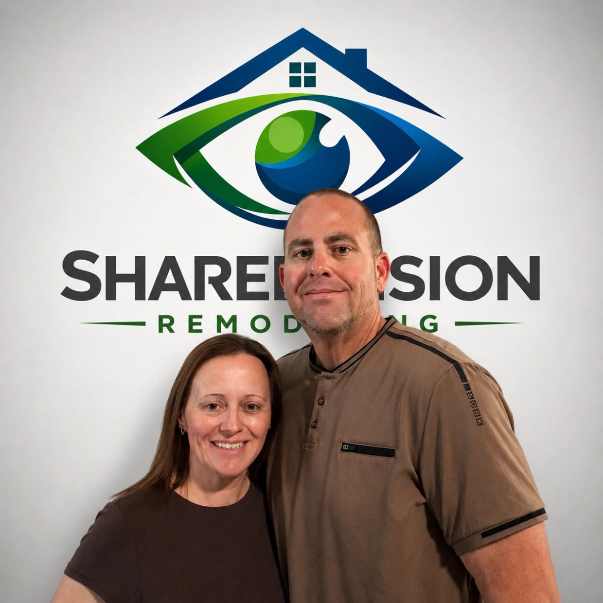 Two people posing in front of a remodeling company logo.