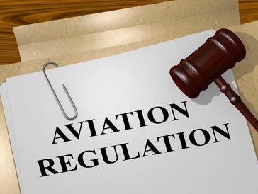 Paper clipped document with "Aviation Regulations" in black type next to judge's gavel