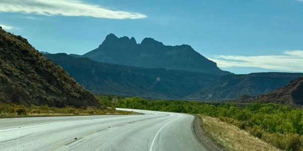 Curving highway with mountains under a clear sky.
