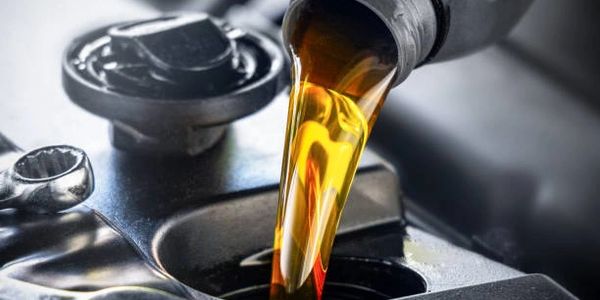 Engine oil being poured into a car engine.