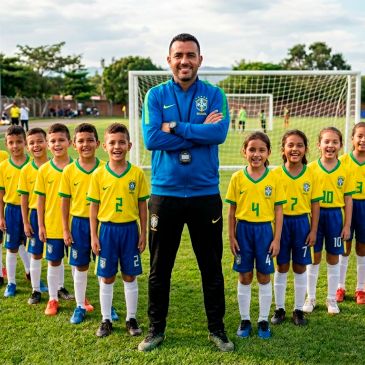 Youth soccer team with coach posing on field in Brazil jerseys.